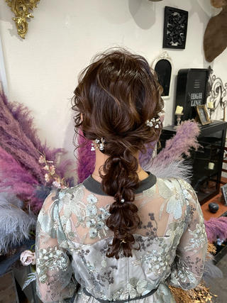 低めの位置でまとめた編み下ろしに、ルーズなニュアンスを加えた上品なヘアアレンジ。トップは程よく崩して立体感を出し、後ろ姿に柔らかな動きと奥行きを演出しています。パールアクセサリーをさりげなく散らすことで、華やかさと女性らしさをプラス。甘すぎず大人っぽい印象で、結婚式やフォーマルなパーティー、特別なお呼ばれシーンにも映える洗練されたスタイルです。 