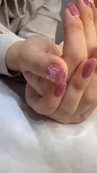 細かなラメが輝くピンクのグラデーションネイルに、立体的なホワイトリボンをあしらったガーリーなデザイン
華やかさの中にも上品さがあり、光の角度できらめく手元がとても女性らしい印象です。
小指にはクリアハートパーツを添えて、可愛らしさをプラス
デートやお出かけはもちろん、普段使いにもぴったりな万能デザインです