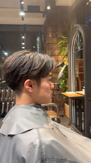 高めの刈り上げにパーマを活かしたセンターパートスタイル 