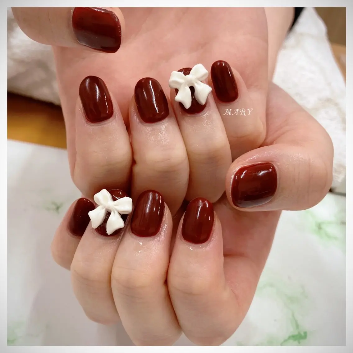ネイル ボルドー ニュアンスネイル ワンカラーネイル 赤色 リボン ハンドネイル Mary nail .narumiのネイルデザイン