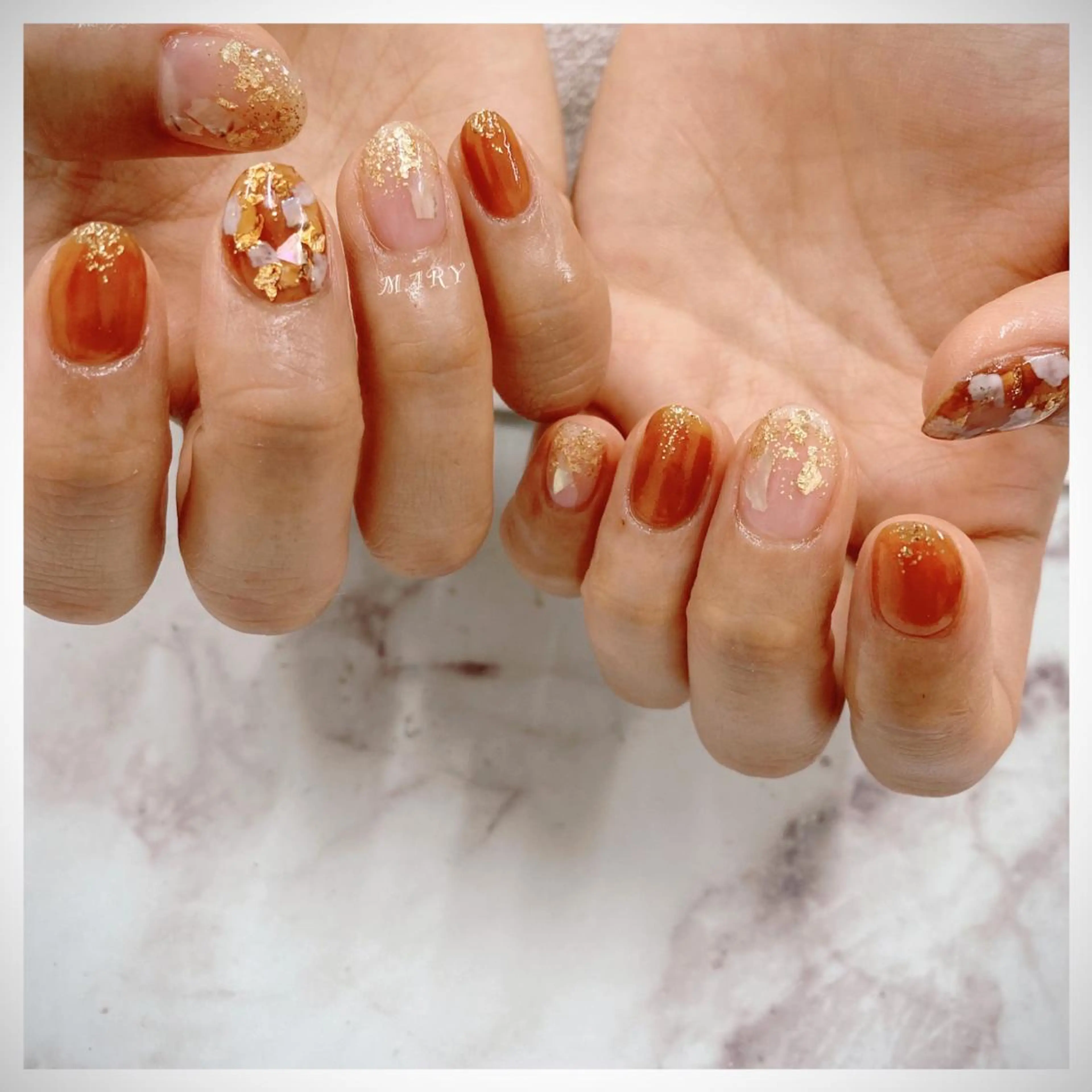 ネイル ブラウン ゴールド キラキラネイル ニュアンスネイル オレンジ ハンドネイル Mary nail .narumiのネイルデザイン
