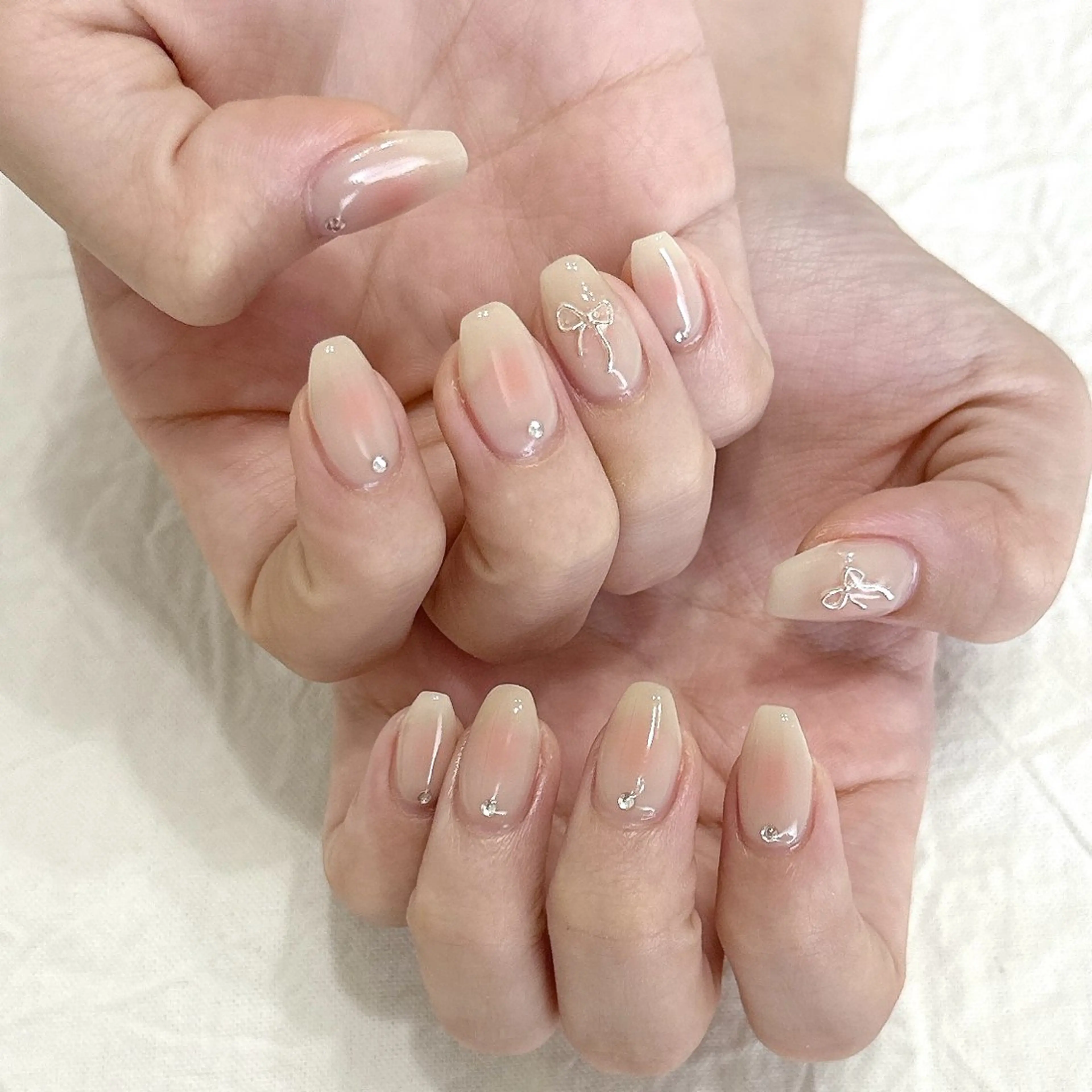 ネイル チークネイル ピンク リボン シルバー ストーンネイル ハンドネイル peaberry nailのネイルデザイン