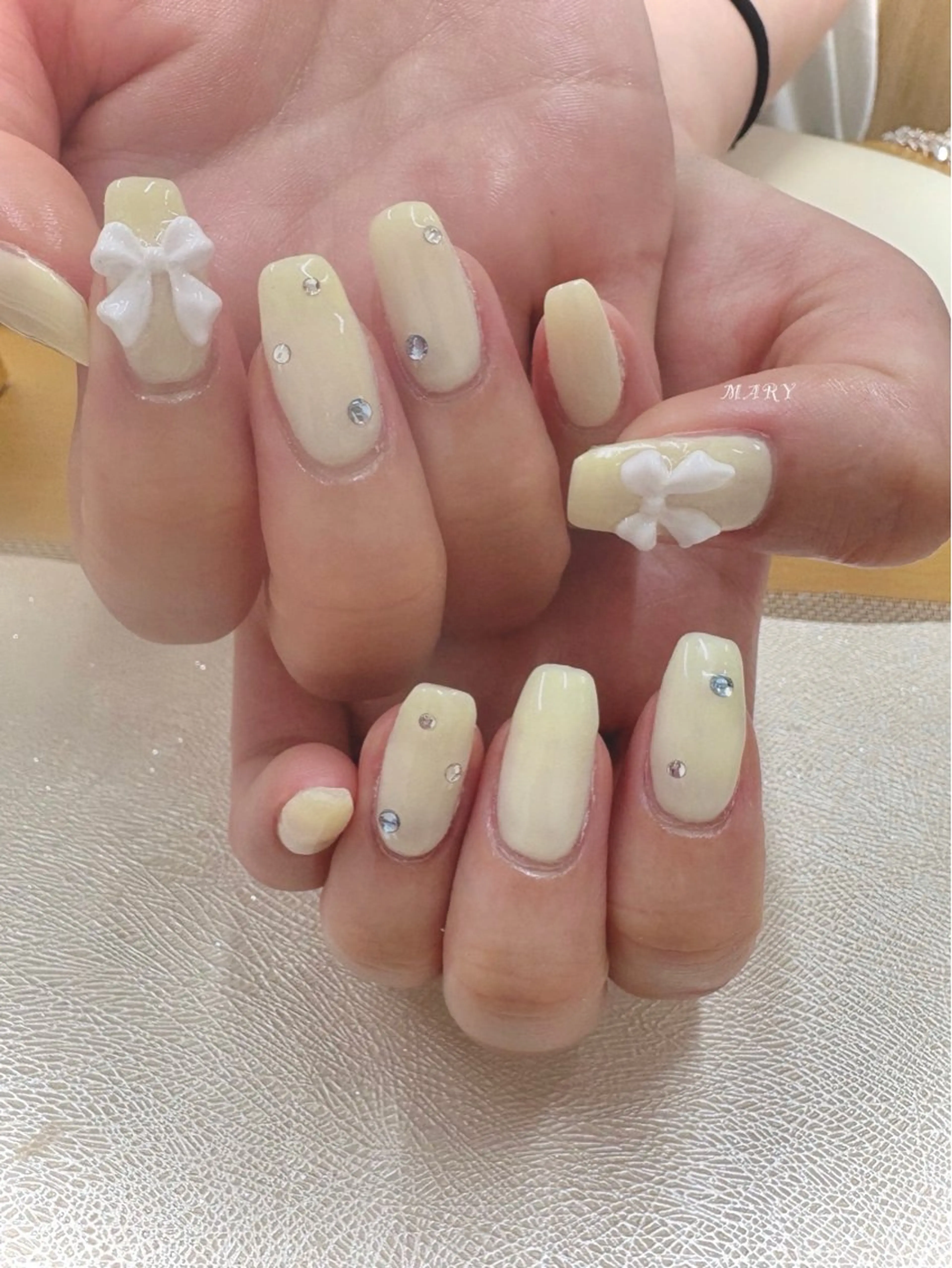 ネイル ニュアンスネイル ワンカラーネイル リボン スクエアネイル 黄色 ハンドネイル Mary nail .narumiのネイルデザイン