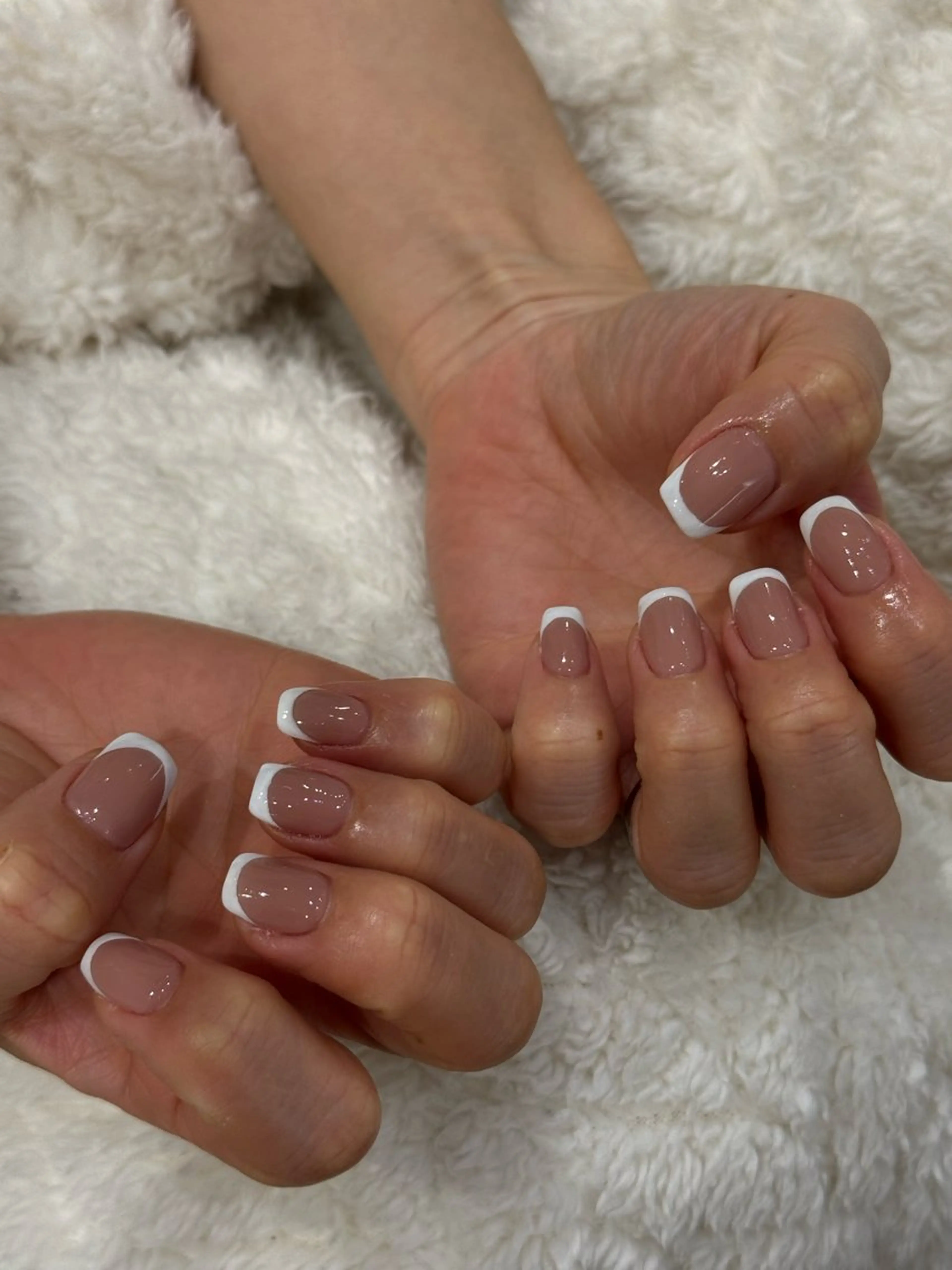 ハンド肌なじみの良いピンクベージュに白フレンチネイル(オフなし)の写真