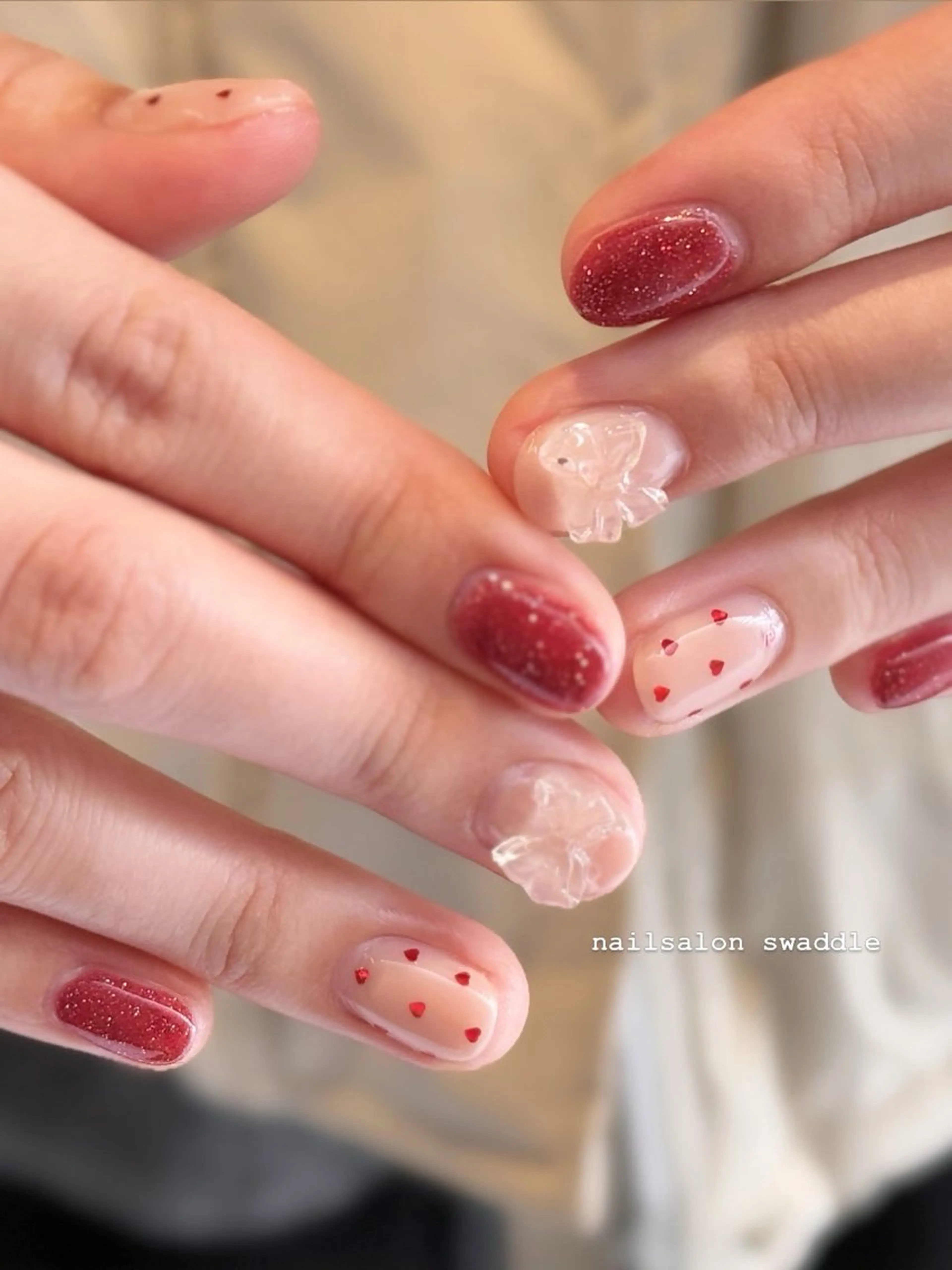 ネイル ハート ホログラムネイル 赤色 リボン ハンドネイル nail salon swaddle 🪽のネイルデザイン