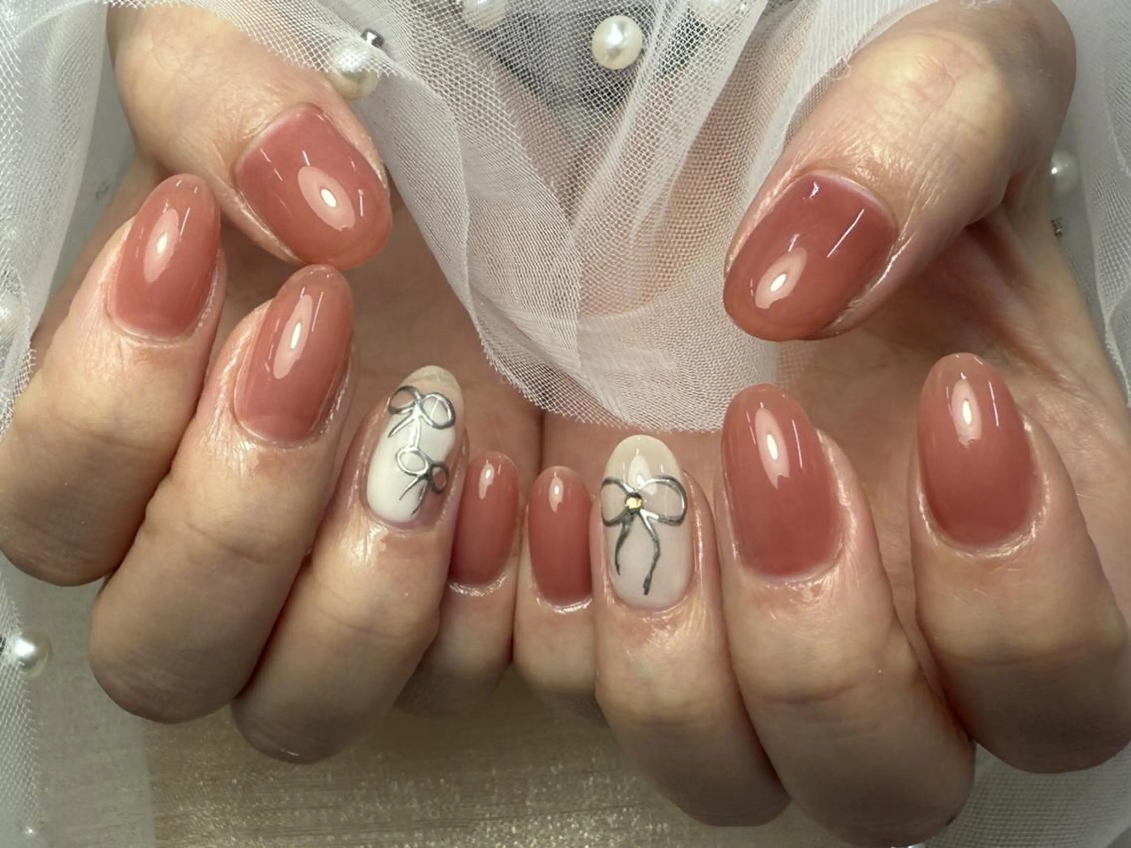 ネイル アートネイル ピンク ピンクベージュ リボン ストーンネイル ハンドネイル ToliyDeliy Nail Salonのネイルデザイン
