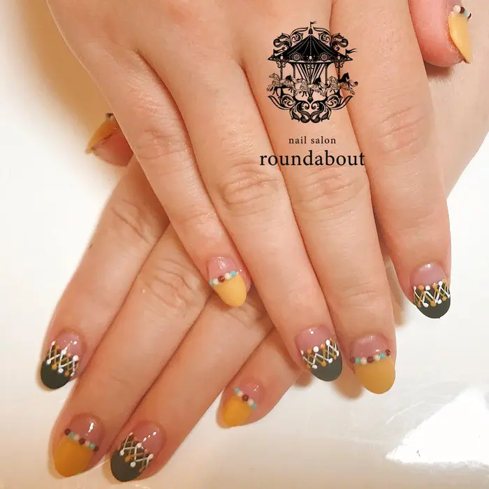 マスタードイエローとブラックのストレートフレンチ 刺繍風のアートとガラスブリオンがポイント Nailsalon Roundabout所属 Nailsalon Roundaboutのネイルデザイン ミニモ