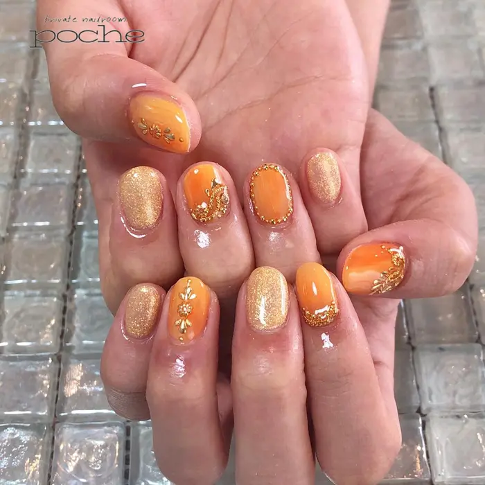 オレンジの秋ネイル スタッズアートがオシャレ Nail Room Poche所属 工藤 理恵のネイルデザイン ミニモ